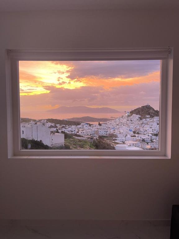 a window in a room with a view of a city at Skala Sunset Hotel and spa in Ios Chora