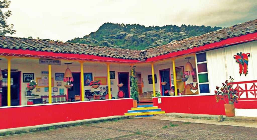 una casa roja y blanca con una montaña en el fondo en Finca Recreacional Marcelandia, en Santa Rosa de Cabal