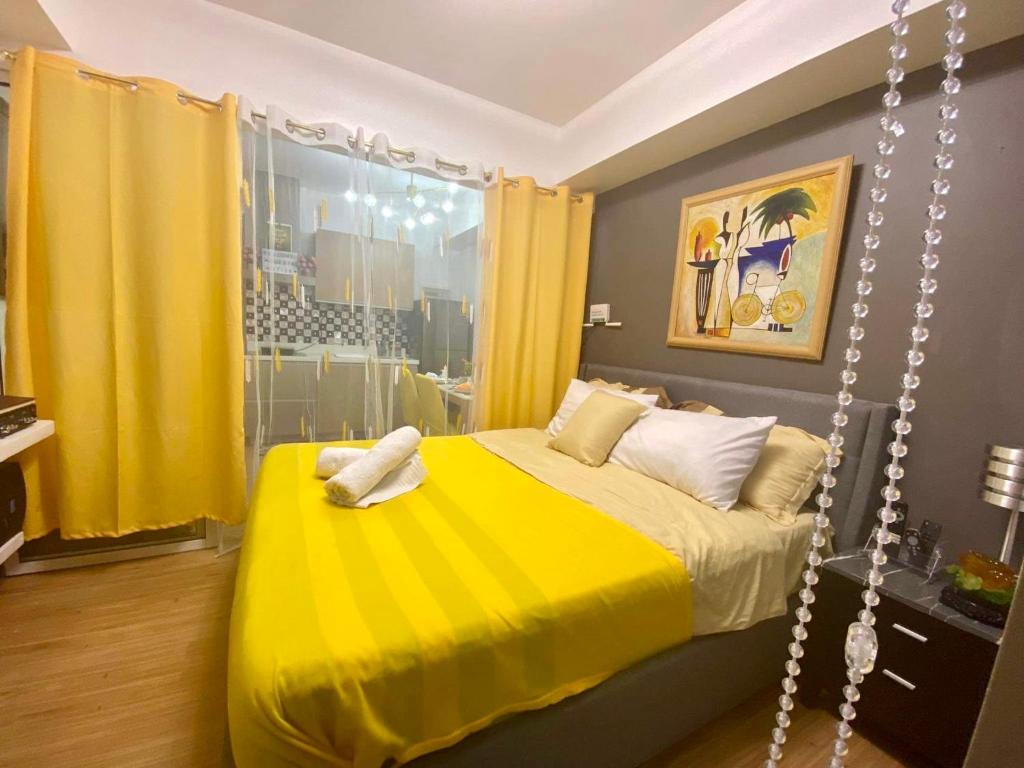 a bedroom with a yellow bed and yellow curtains at Azure south urban beach resort near airport in Manila