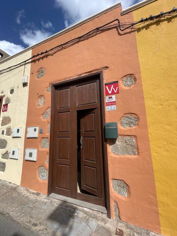 una puerta marrón en el lateral de un edificio en Casa Mojo, en Agüimes