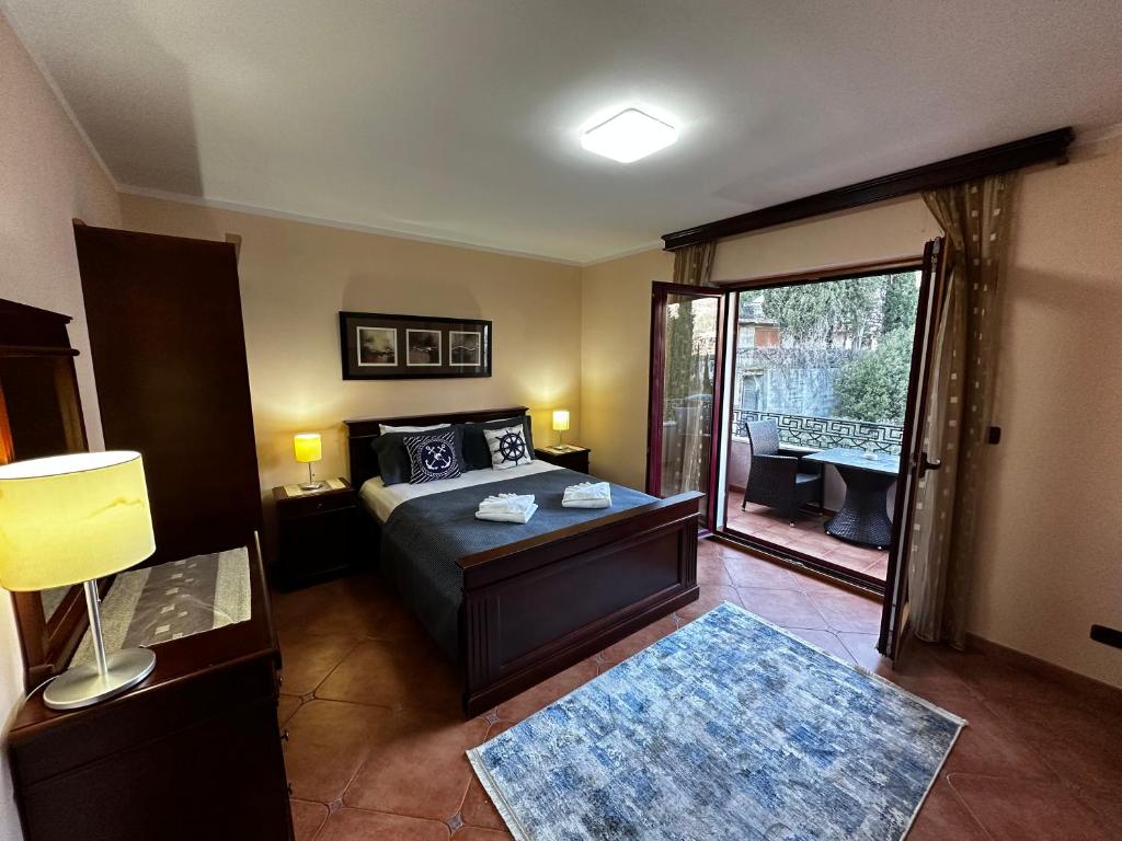 1 dormitorio con 1 cama y puerta a un balcón en Villa Beatrix Budva, en Budva