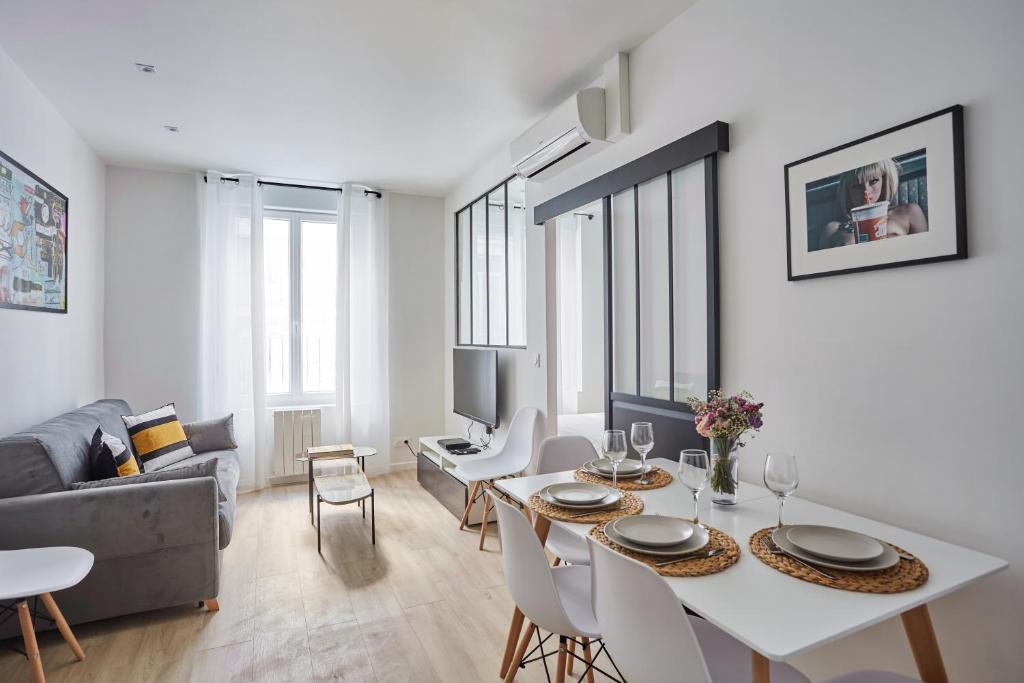 ein Wohnzimmer mit einem weißen Tisch und Stühlen in der Unterkunft Residence Center of Paris by Studio prestige in Paris