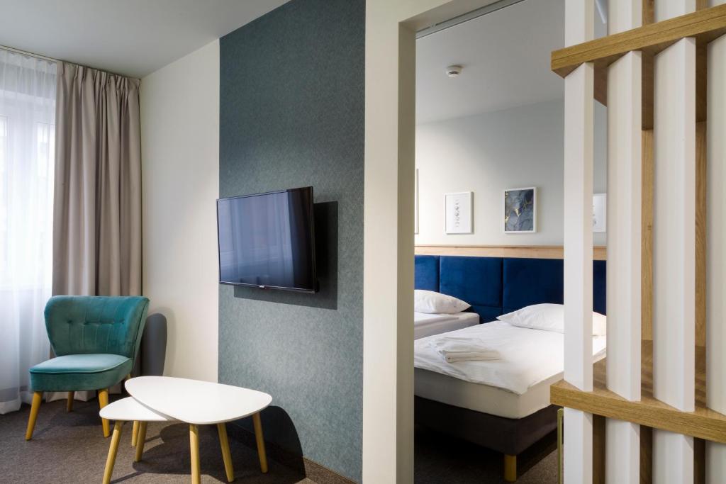 a hotel room with a bed and a tv at Halo Toruń in Toruń