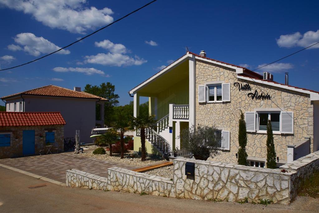 a house with a stone wall in front of it at Matteo in Malinska