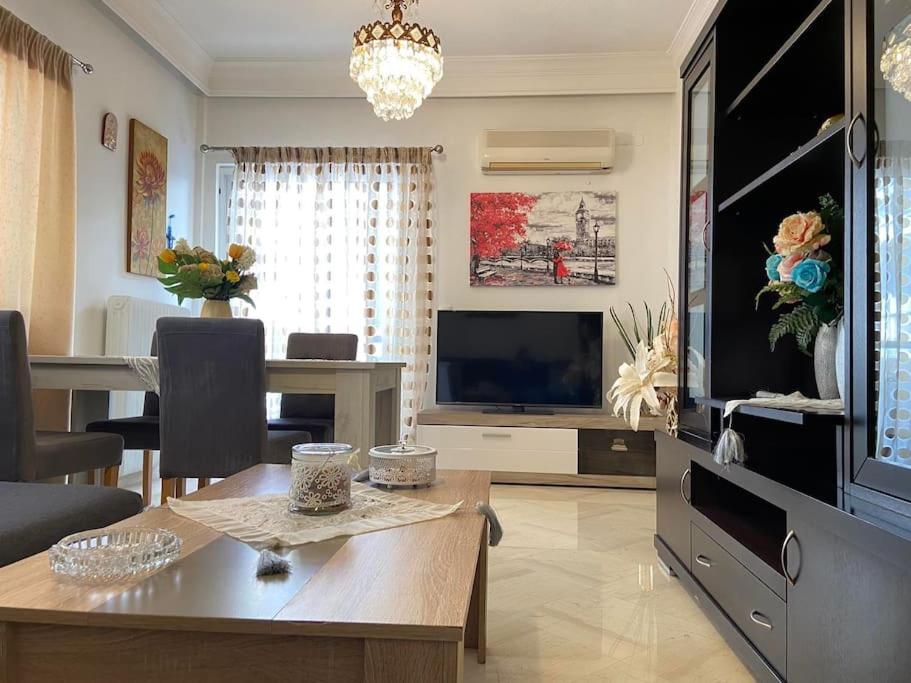 een woonkamer met een tafel en een televisie bij Irene's Guest Home in Chalkida