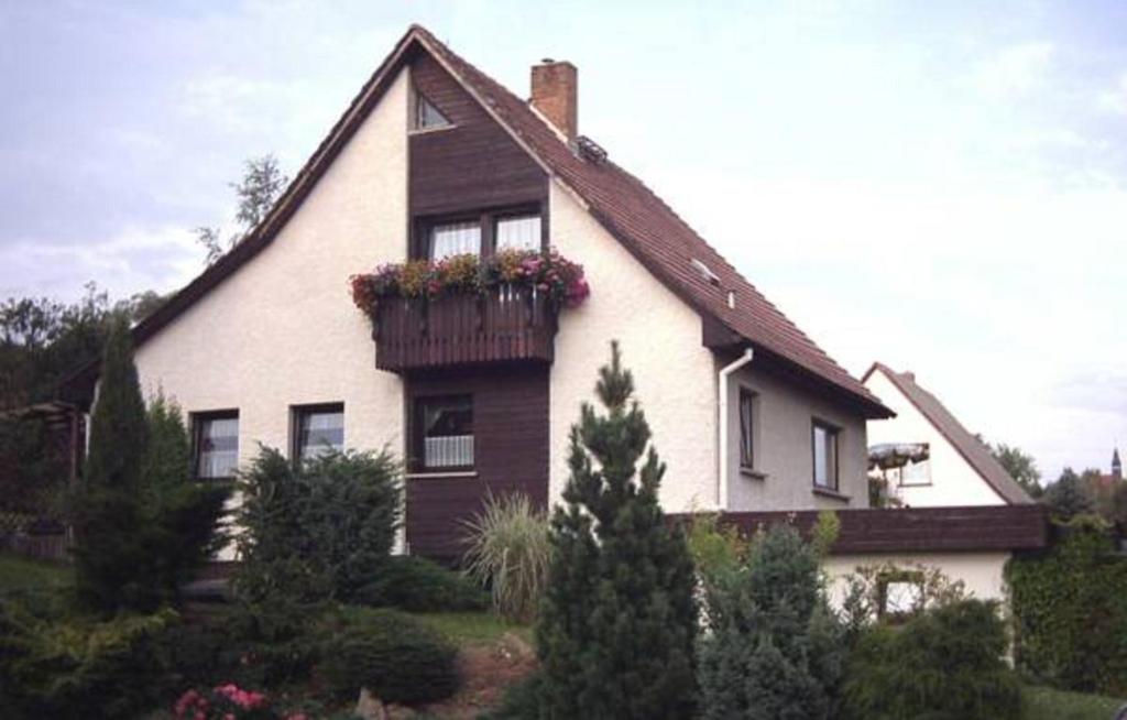 una casa bianca con un balcone fiorito di Pension-Reiche a Struppen