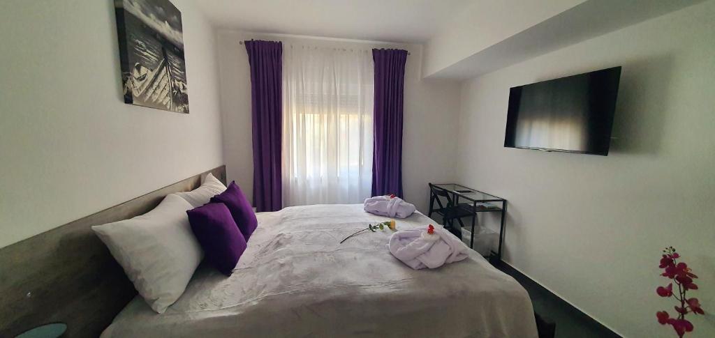 a bedroom with a bed with purple pillows at Blue Diamond **** in Varaždin