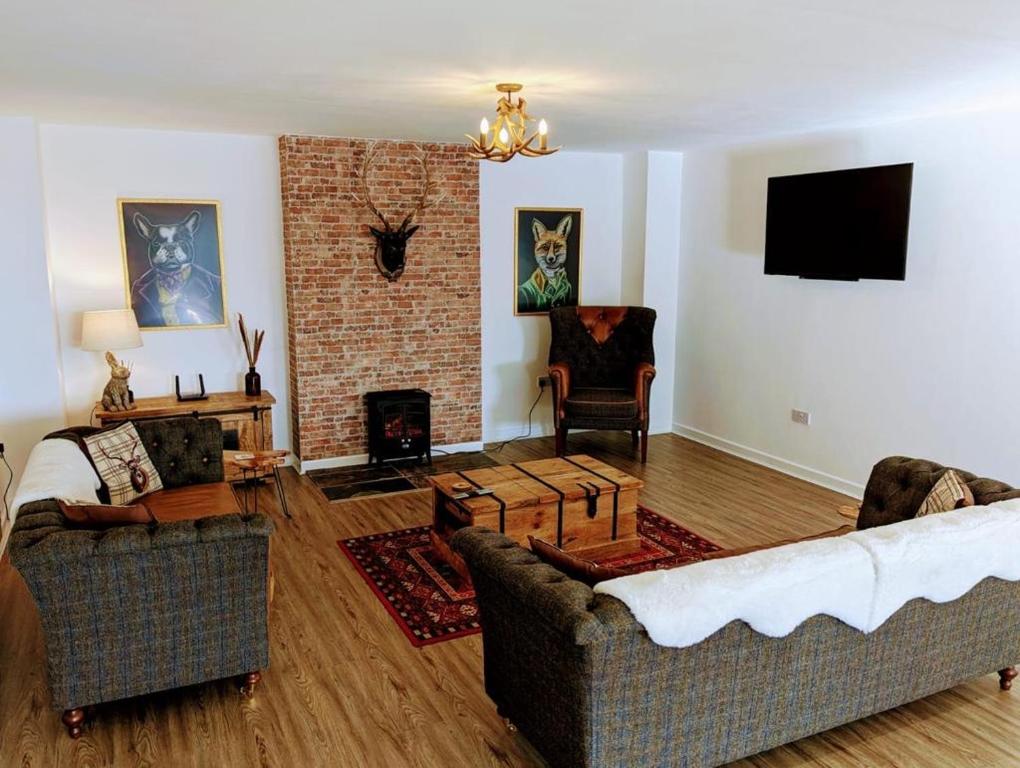 uma sala de estar com dois sofás e uma lareira em Country Lodge Retreat em Lydney