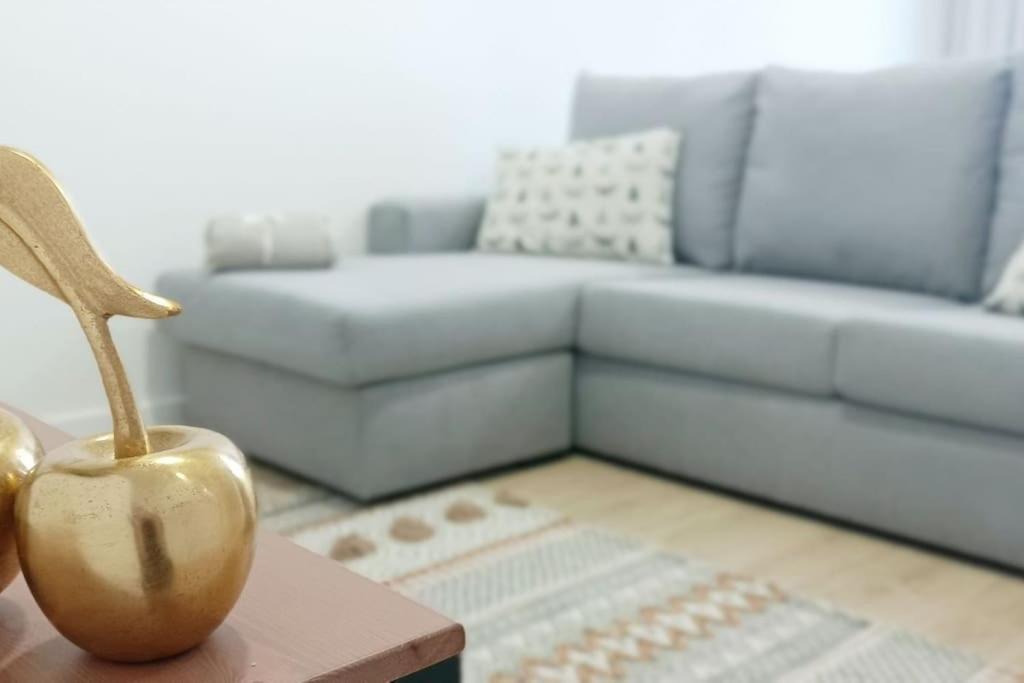 een woonkamer met een bank en een appel op een tafel bij Herba de namorar- Céntrico apartamento en Cedeira in Cedeira