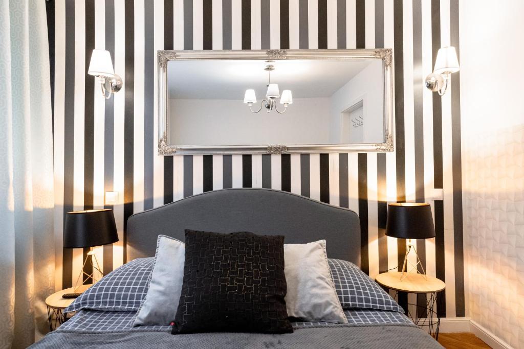 a bedroom with a bed with a mirror and two lamps at ClickTheFlat Old Town Apart Rooms in Warsaw