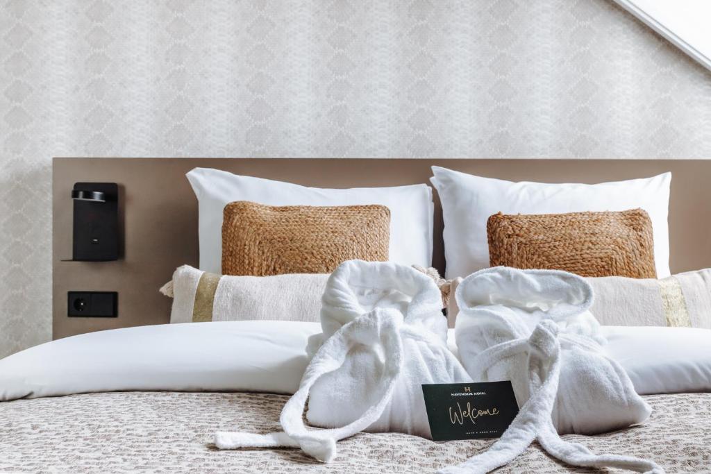 a bed with white towels and pillows on it at Havendijk Hotel in Schiedam