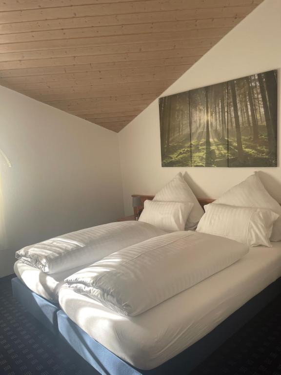 ein großes Bett mit weißer Bettwäsche und Kissen in der Unterkunft KRYSTALL Hotel in Filderstadt