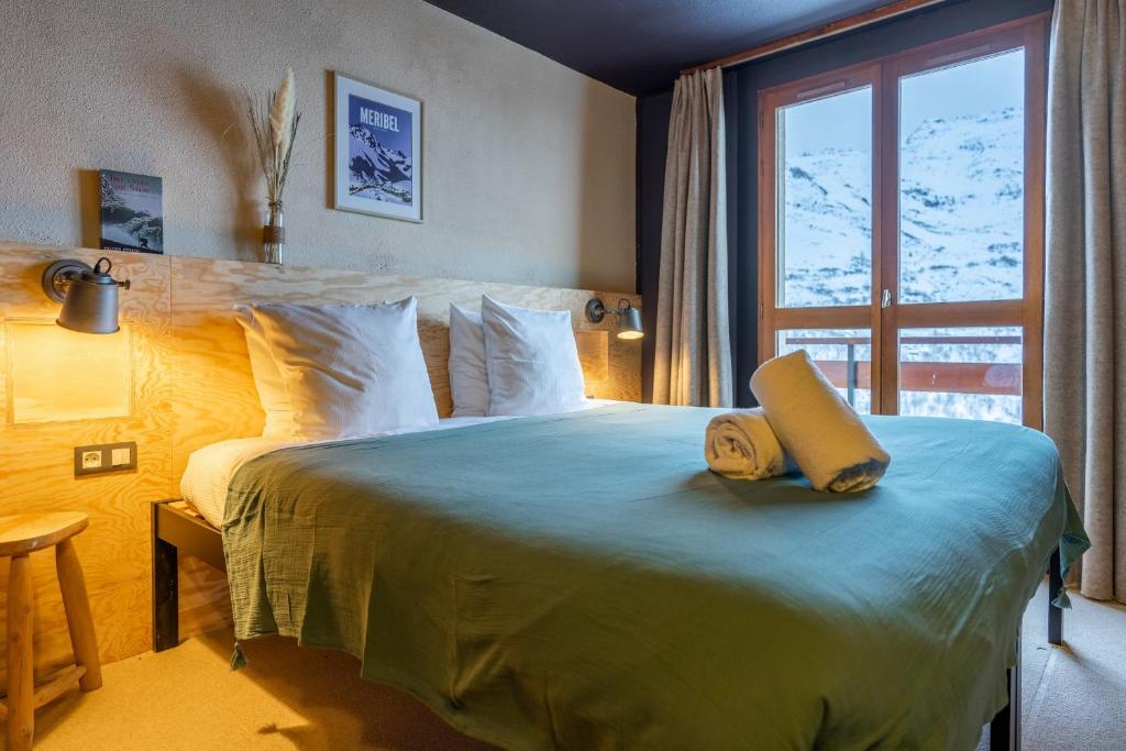 a bedroom with a bed with a yellow book on it at ho36 Les Menuires in Les Menuires