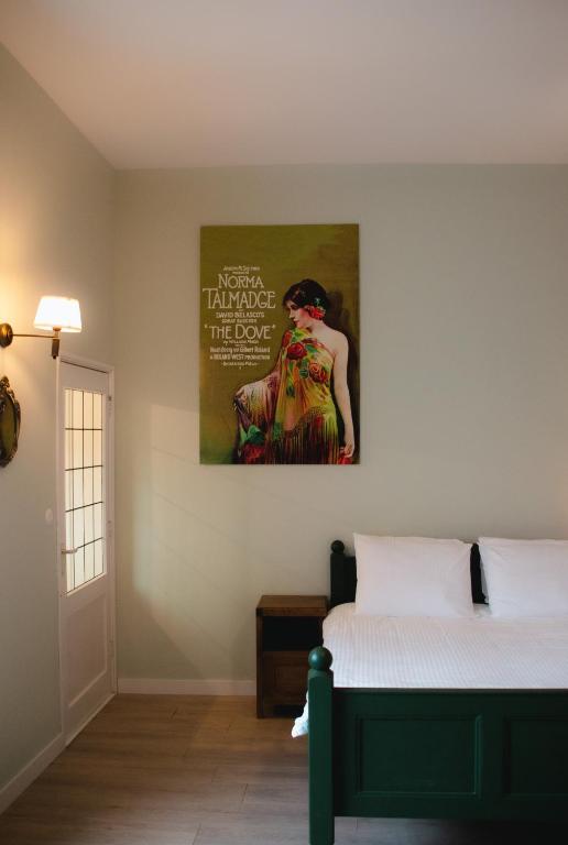 een slaapkamer met een bed en een schilderij aan de muur bij Appartement 'de Stadstuin' in Harderwijk