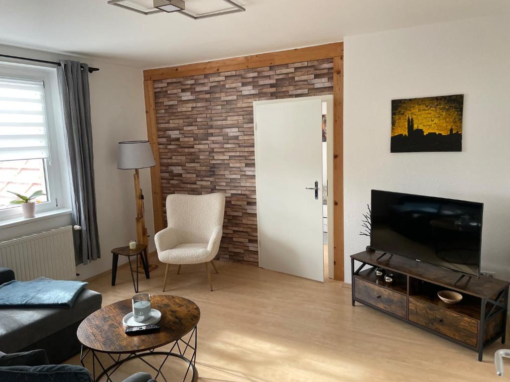 een woonkamer met een televisie en een bakstenen muur bij Fewo 1 - a79673 in Maagdenburg
