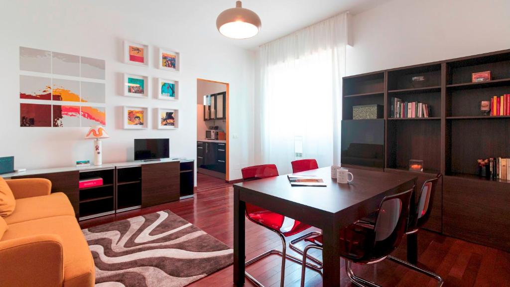 uma sala de estar com uma mesa e um sofá em Italianway - Nona Strada 7 em Segrate