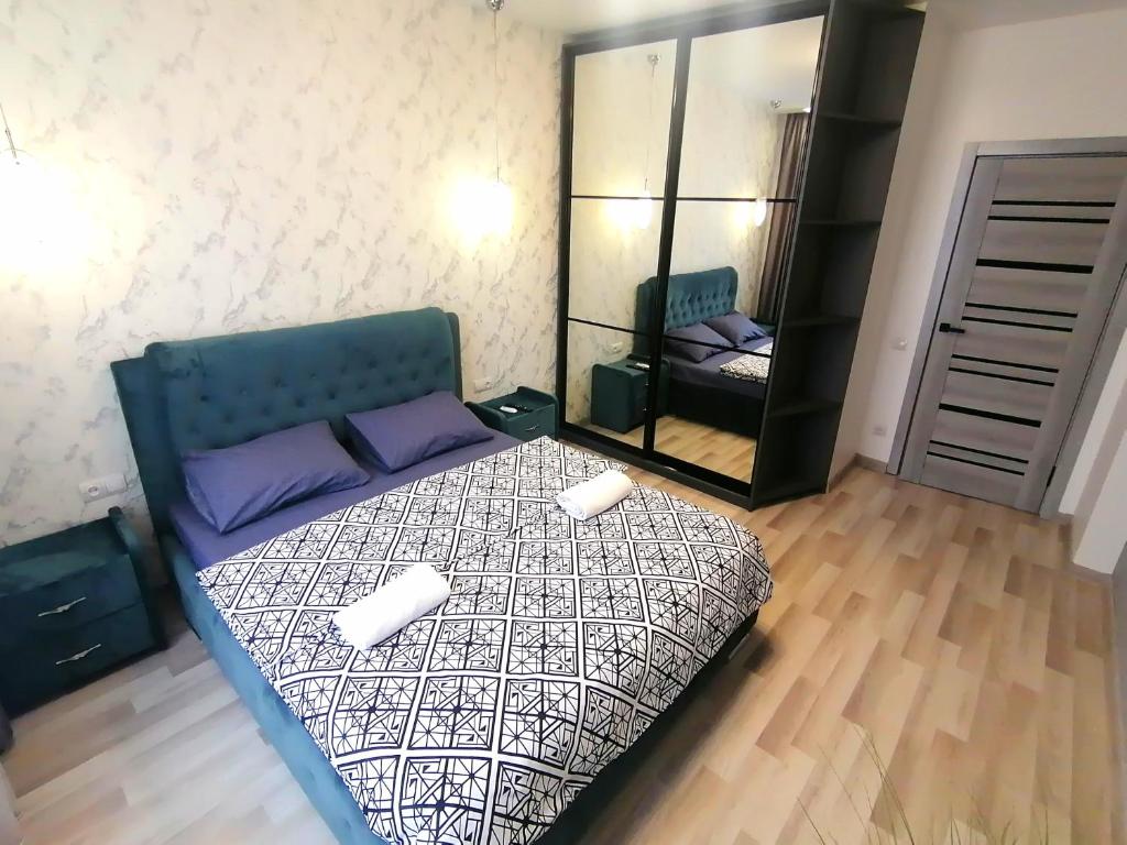 una camera da letto con un letto con due cuscini e uno specchio di Новобудова Сам центр вул Шевченка 60 Оперний 10хв a Lviv