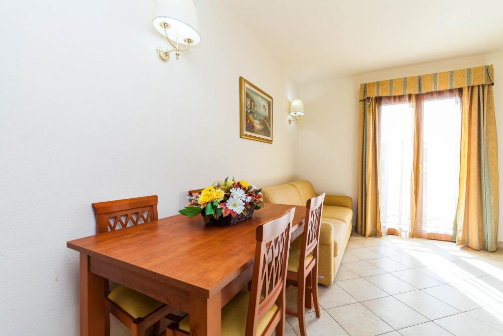 Regina Elena Apartments في أولبيا: غرفة معيشة مع طاولة خشبية وأريكة