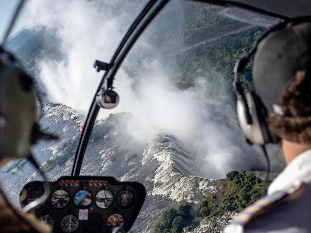 einen Blick aus dem Flügel eines Flugzeugs, das über einen Berg fliegt in der Unterkunft Mukwa River Lodge in Livingstone