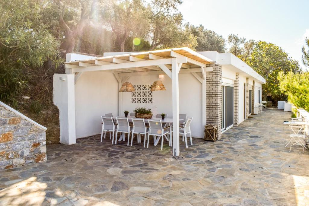 un patio con mesa y sillas frente a una casa en View Villa en Skíathos