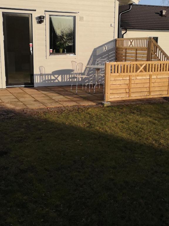 eine Holzterrasse mit Stühlen auf einem Haus in der Unterkunft Nybyggd marklägenhet strax utanför Torekov! in Båstad