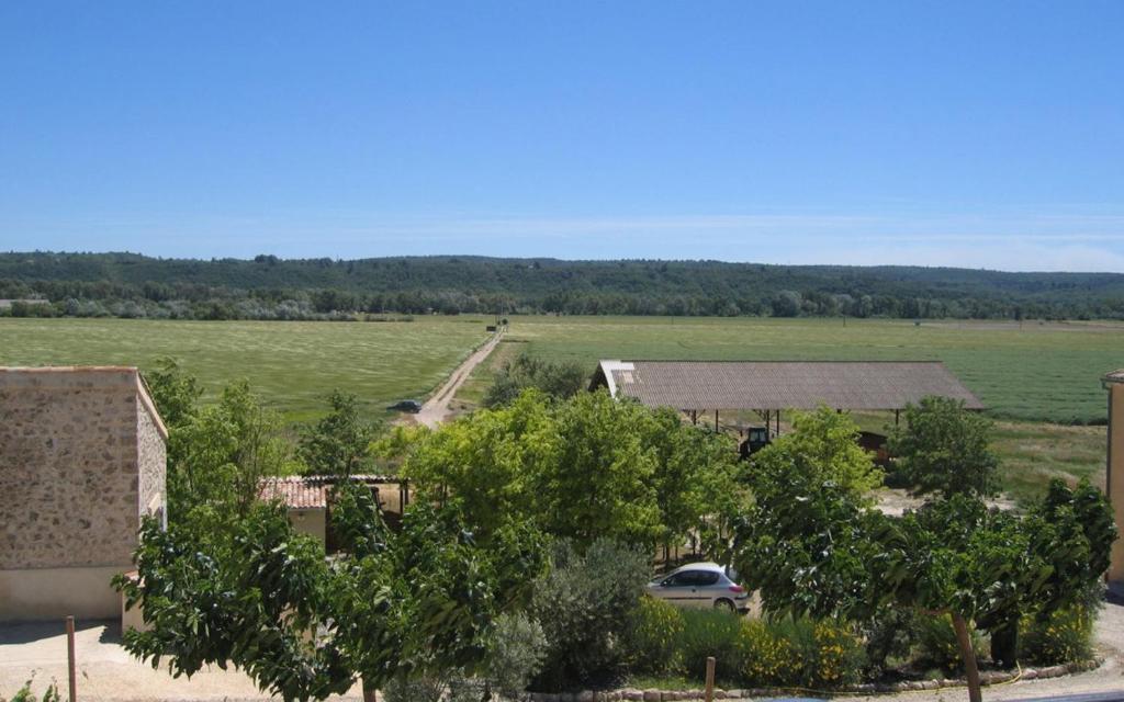 une vue aérienne d'un grand champ avec un bâtiment et une voiture dans l'établissement Campagne la clape g2116, à Vinon-sur-Verdon
