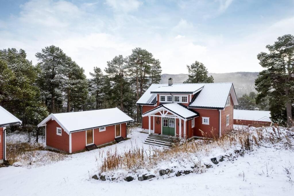 ein rotes Haus mit Schnee auf dem Dach in der Unterkunft Smørøyet. Sentral beliggenhet på Geilo. in Geilo
