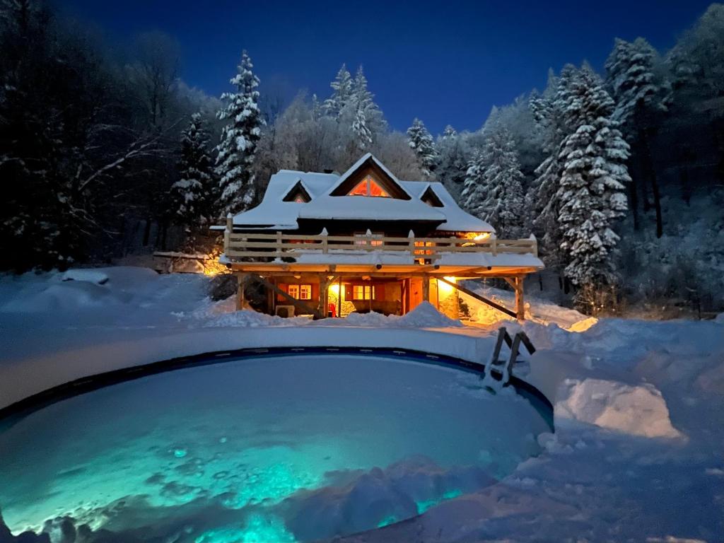 a house in the snow in front of a building at Poziomkowa Chata in Szczyrk