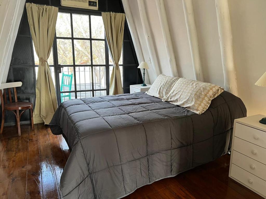 a bedroom with a bed and a large window at Chacras House in Ciudad Lujan de Cuyo