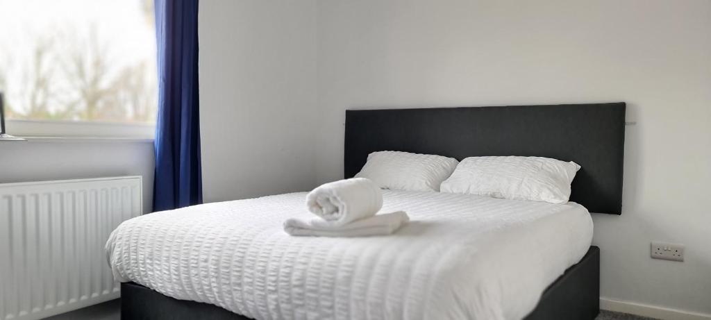 een bed met een witte handdoek erop bij Shanti in Darlington