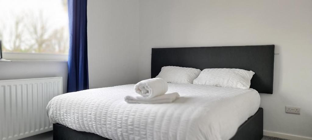 a bed with a white towel on top of it at Shanti in Darlington