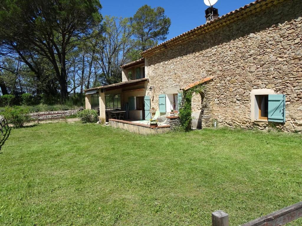 une vue extérieure d'une maison en pierre avec une cour dans l'établissement Le mas des valettes, à Pontevès