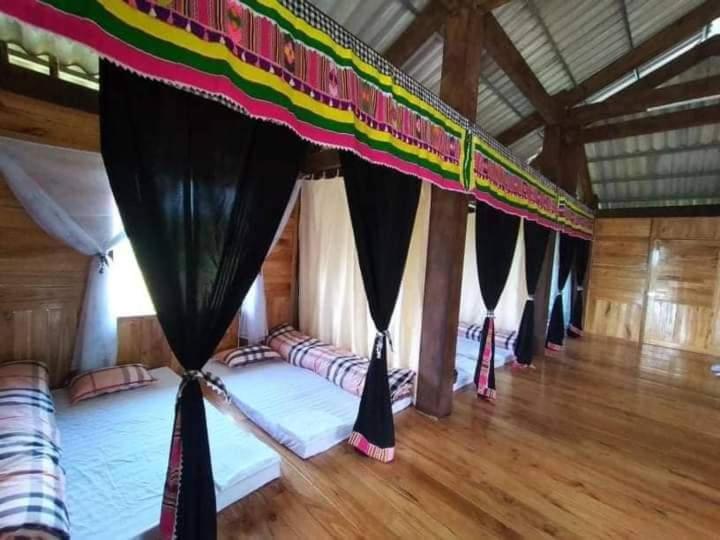 Yên BáiにあるHomestay tuấn bảyの黒いカーテン付きの部屋のベッド1列