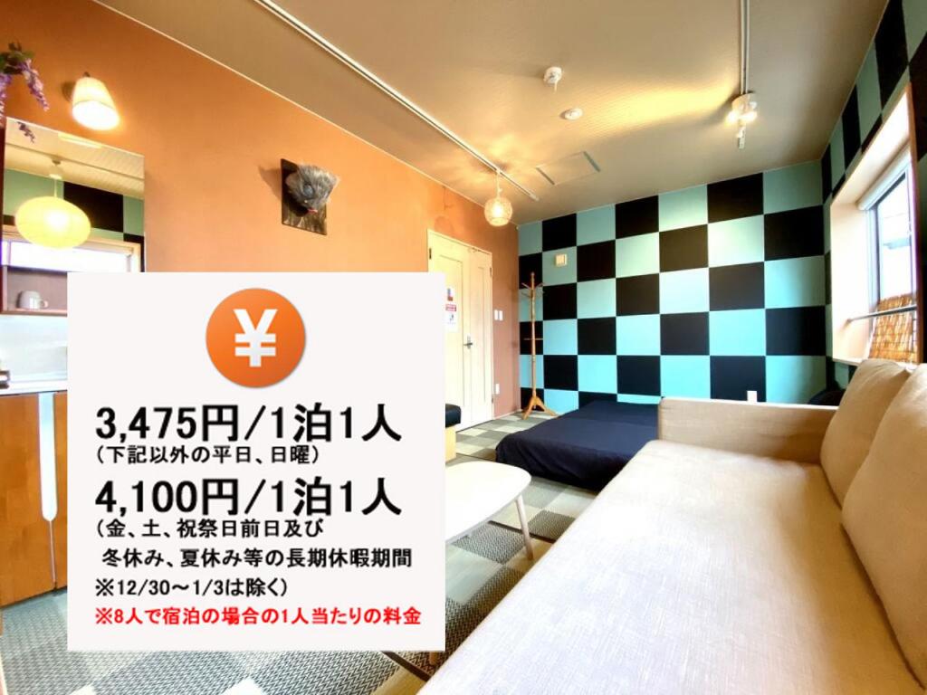 een kamer met een bed en een bord in een kamer bij Hostel Kay 101&102 in Osaka