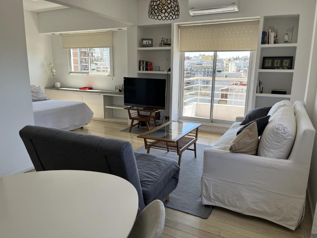 a living room with a couch and a tv at Recoleta Apartment in Buenos Aires