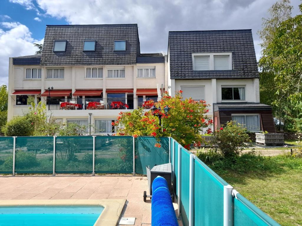 ein Haus mit einem Pool vor einem Haus in der Unterkunft Hotel La Longue Vue in Gennes
