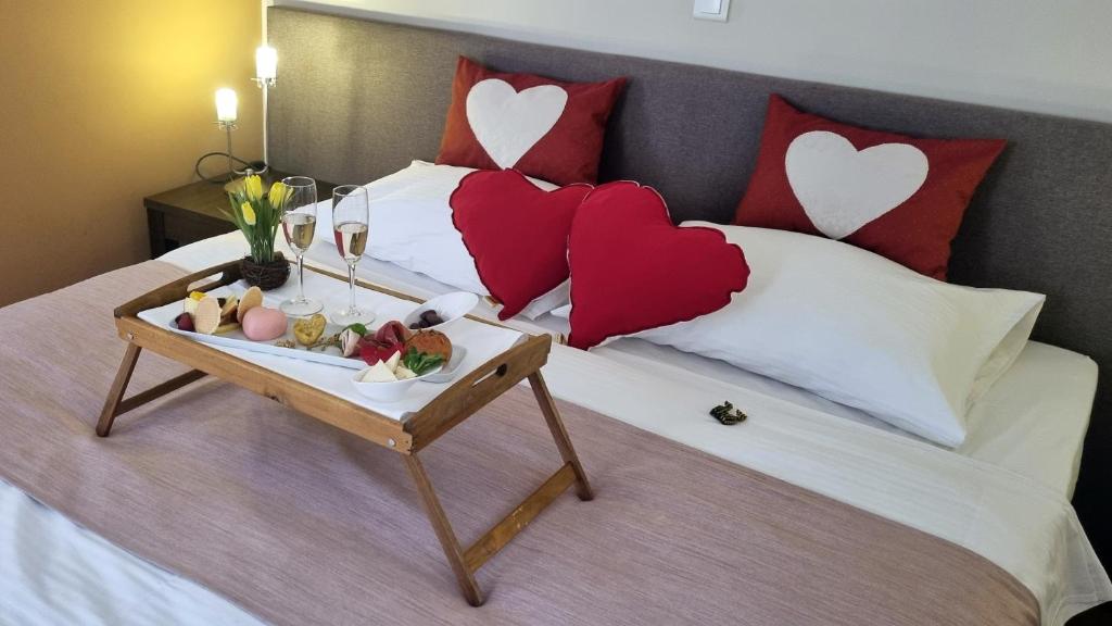 - un plateau de nourriture sur un lit avec des oreillers cardiaques dans l'établissement Sobe Bernarda, à Varaždinske Toplice