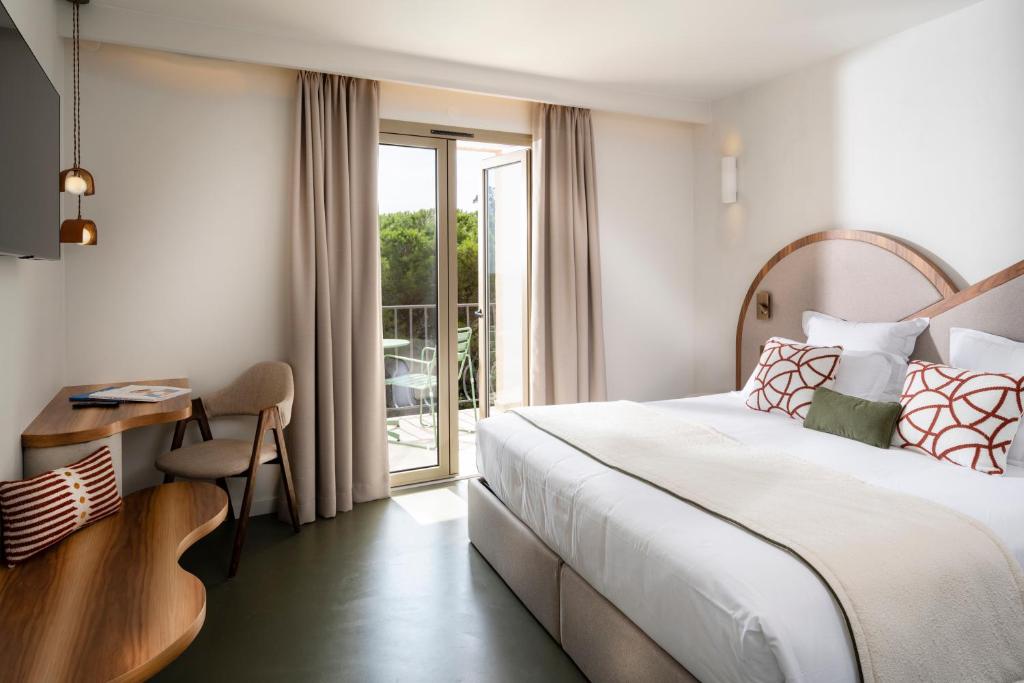 Postel nebo postele na pokoji v ubytování Hôtel du Parc Cavalaire sur Mer