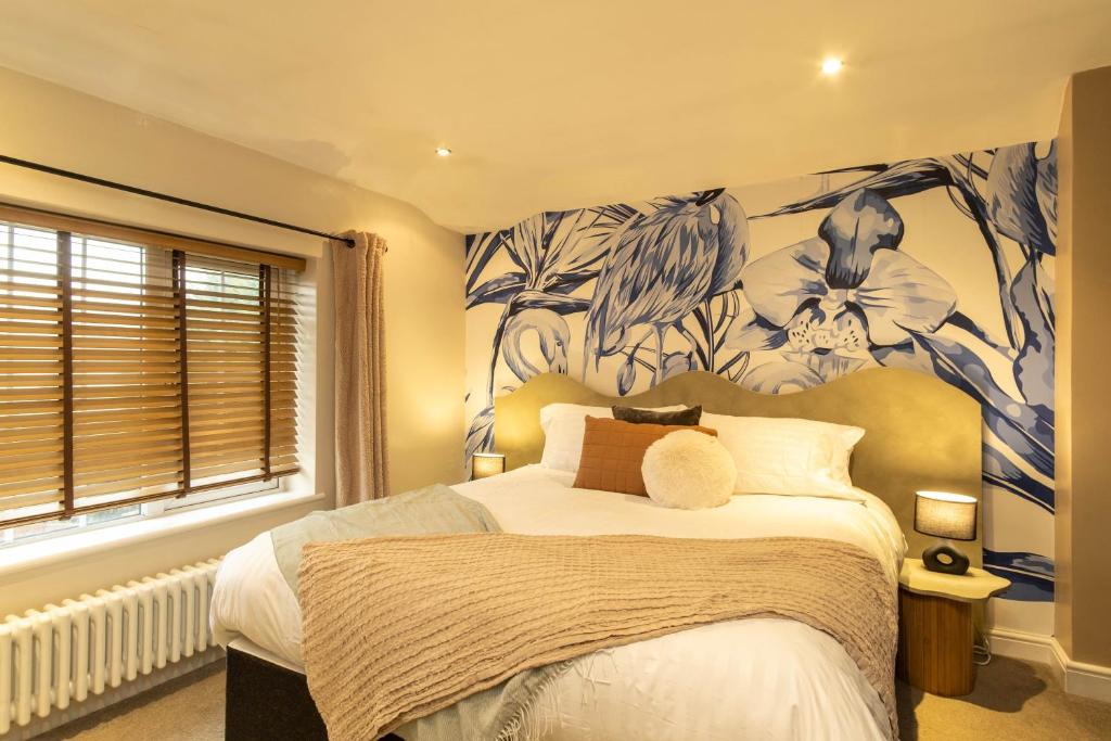 a bedroom with a bed with a blue and white wallpaper at Flamingo Retreat in Leicester