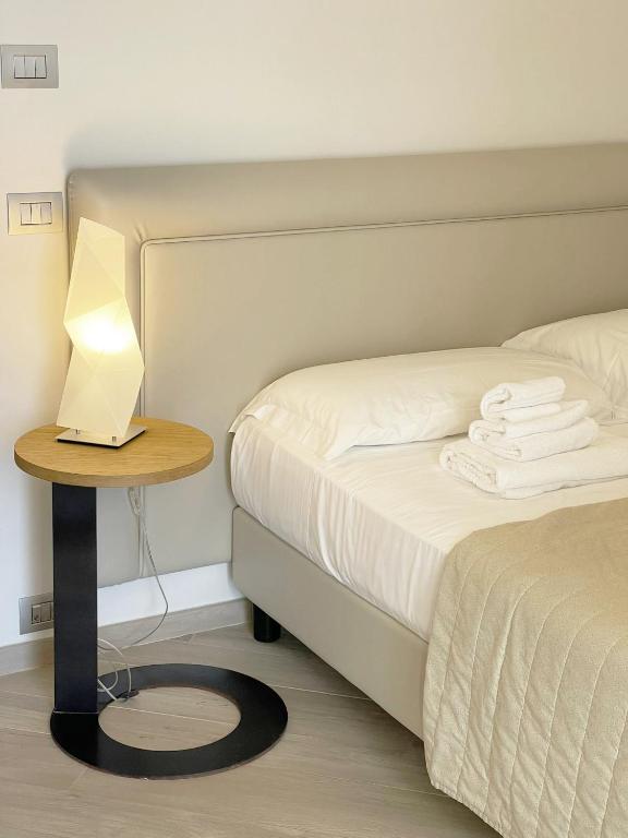 a bed with a table with a lamp on it at Daedalium in Marina di Palma