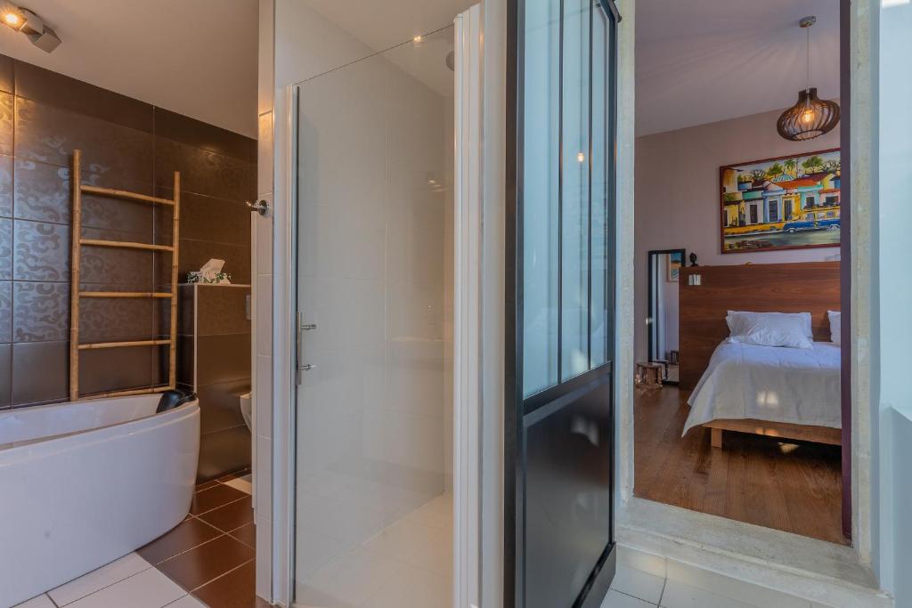 a bathroom with a shower and a bedroom with a bed at Magnifique maison avec piscine a Gujan-Mestras in Gujan-Mestras