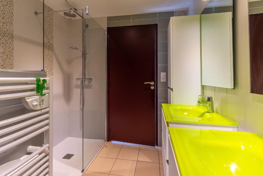 a bathroom with a yellow sink and a shower at Magnifique maison avec piscine a Gujan-Mestras in Gujan-Mestras