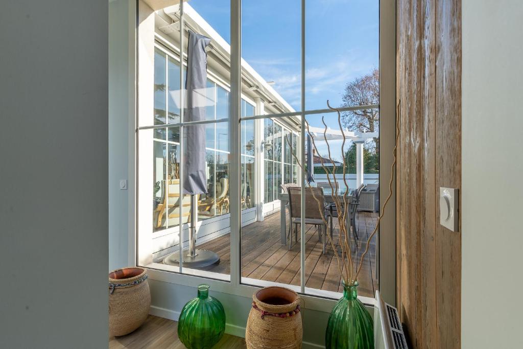 a balcony with green vases sitting on a window sill at Magnifique maison avec piscine a Gujan-Mestras in Gujan-Mestras