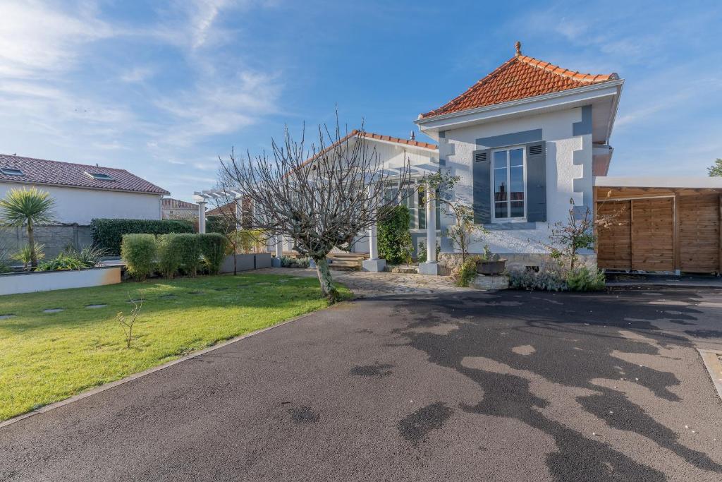 a house with a driveway in front of it at Magnifique maison avec piscine a Gujan-Mestras in Gujan-Mestras