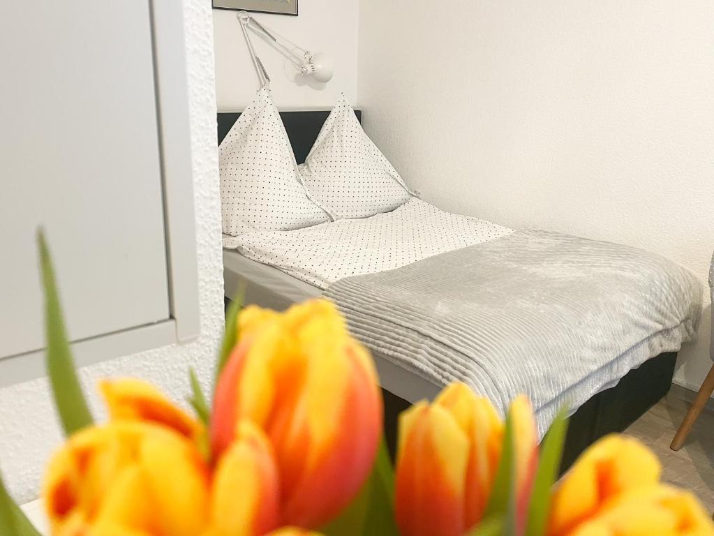a bedroom with a bed and a mirror and flowers at Ferienzimmer Adalonia in Greifswald