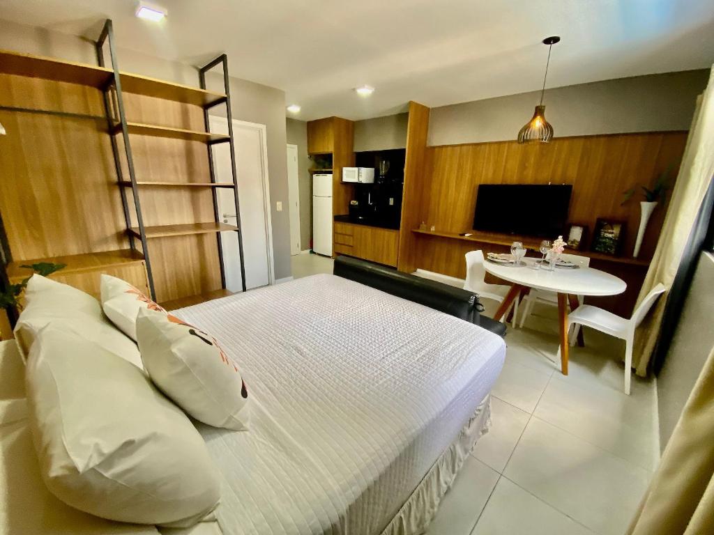 Un dormitorio con una cama y una mesa. en Edifício Time Apto 317 ER Hospedagens, en Maceió