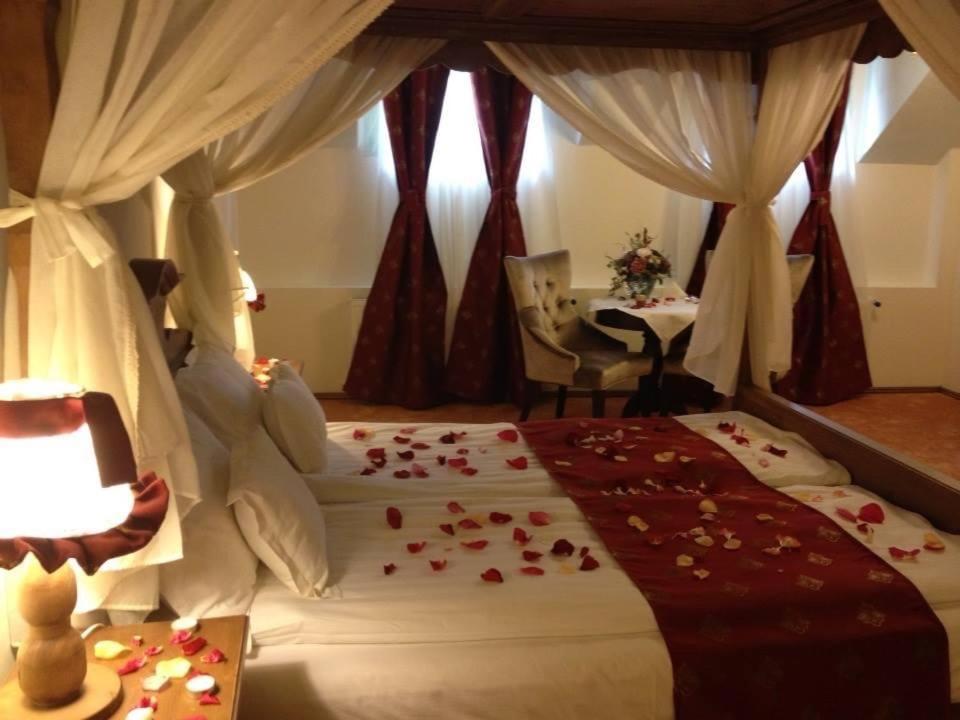 Un dormitorio con una cama con rosas. en Hotel Villa Franca, en Sighişoara