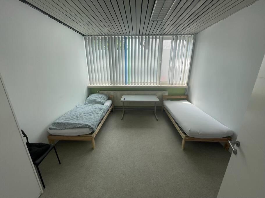 ein kleines Zimmer mit 2 Betten und einem Fenster in der Unterkunft Monteursparadies 4 DZ, 2 Bäder, einfach gut in Haßloch