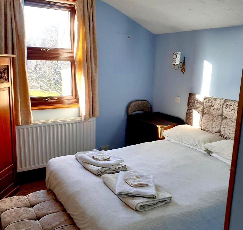 a bedroom with a bed with towels on it at The Guest House in Sheringham in Sheringham