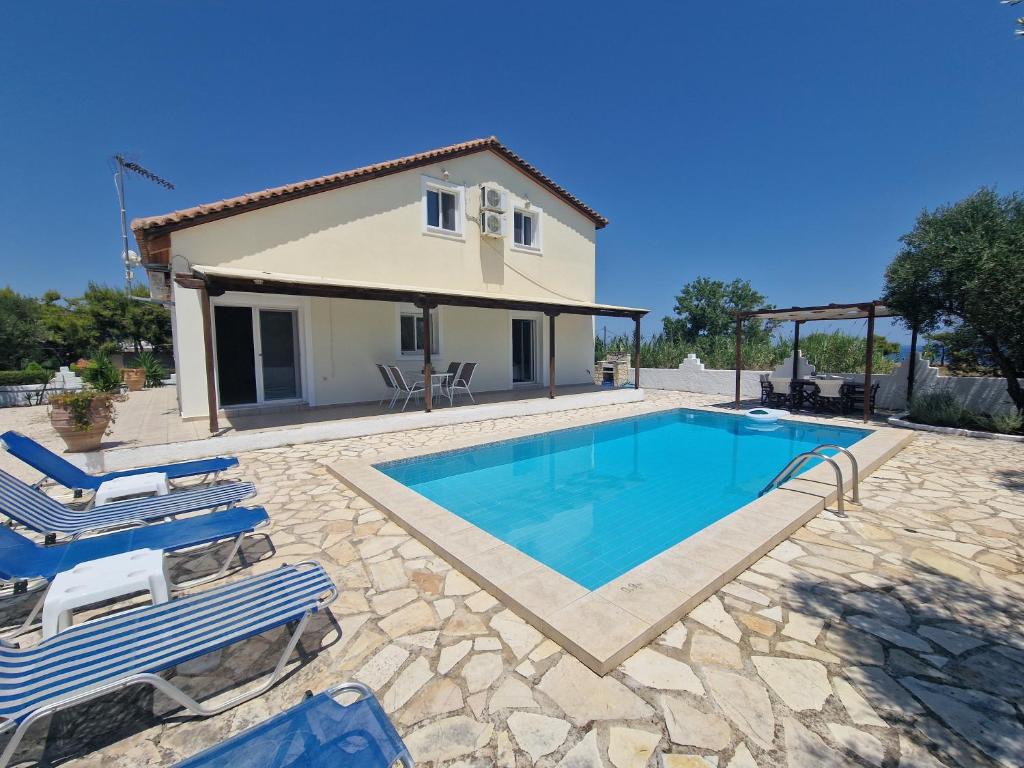 a villa with a swimming pool and a house at Villa Mari in Makris Gialos